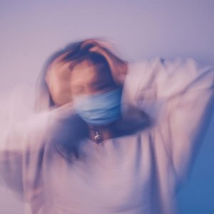 Blurred motion of woman in mask representing pandemic stress and anxiety.